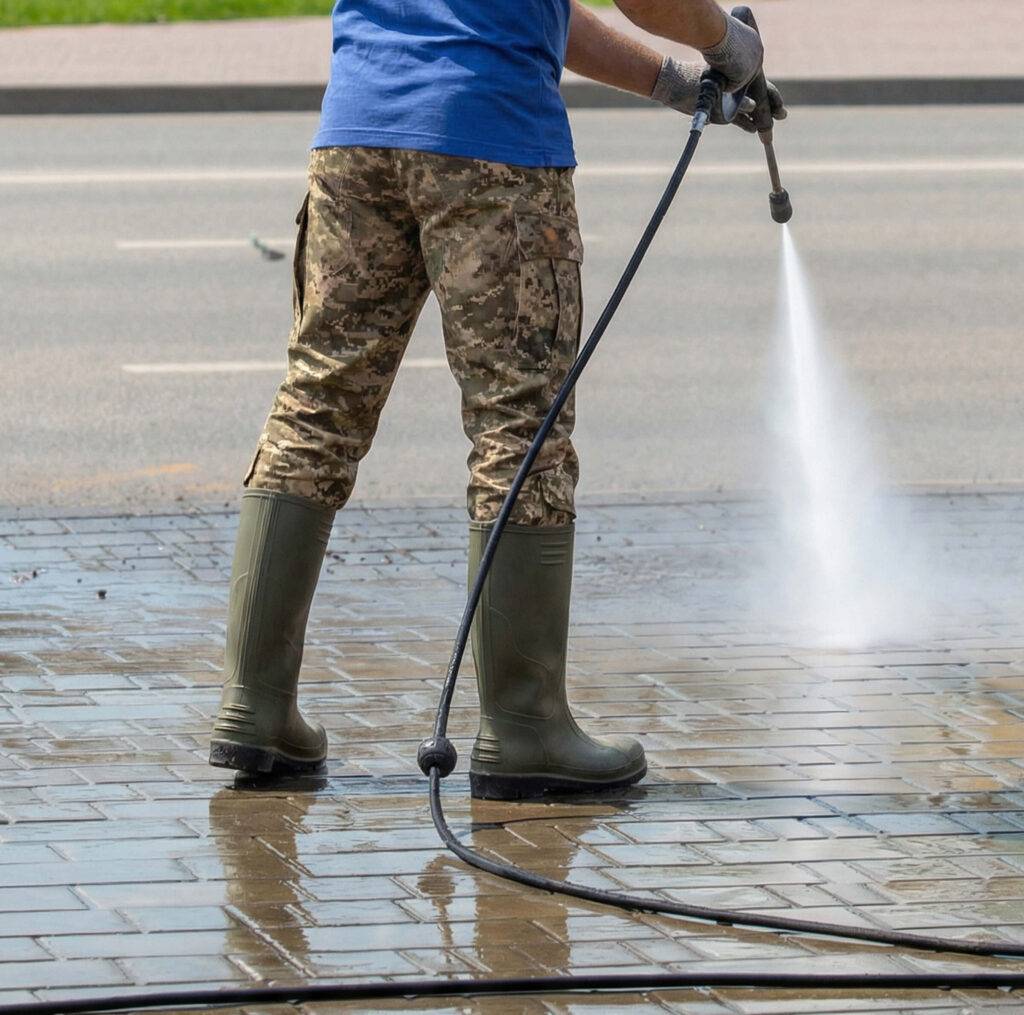 man power washing concrete sidewalk