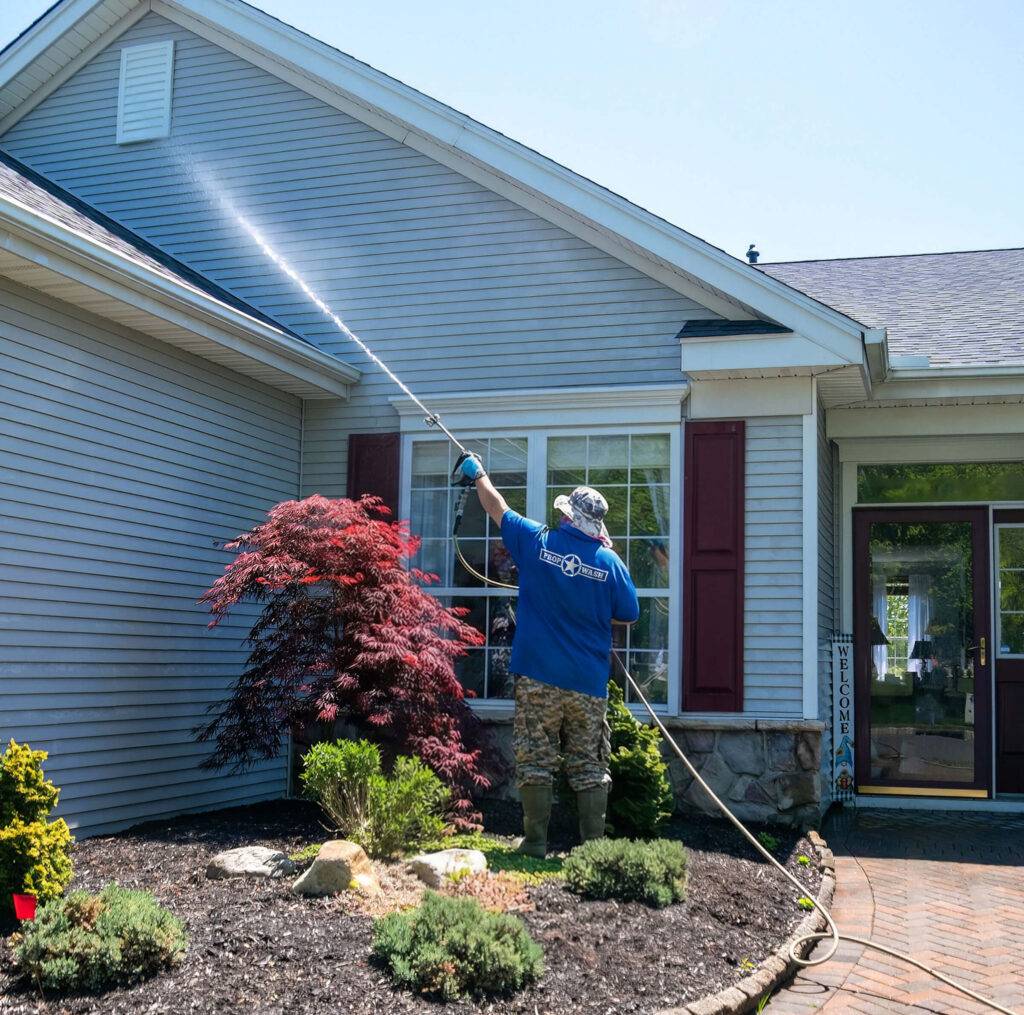 man power washing house