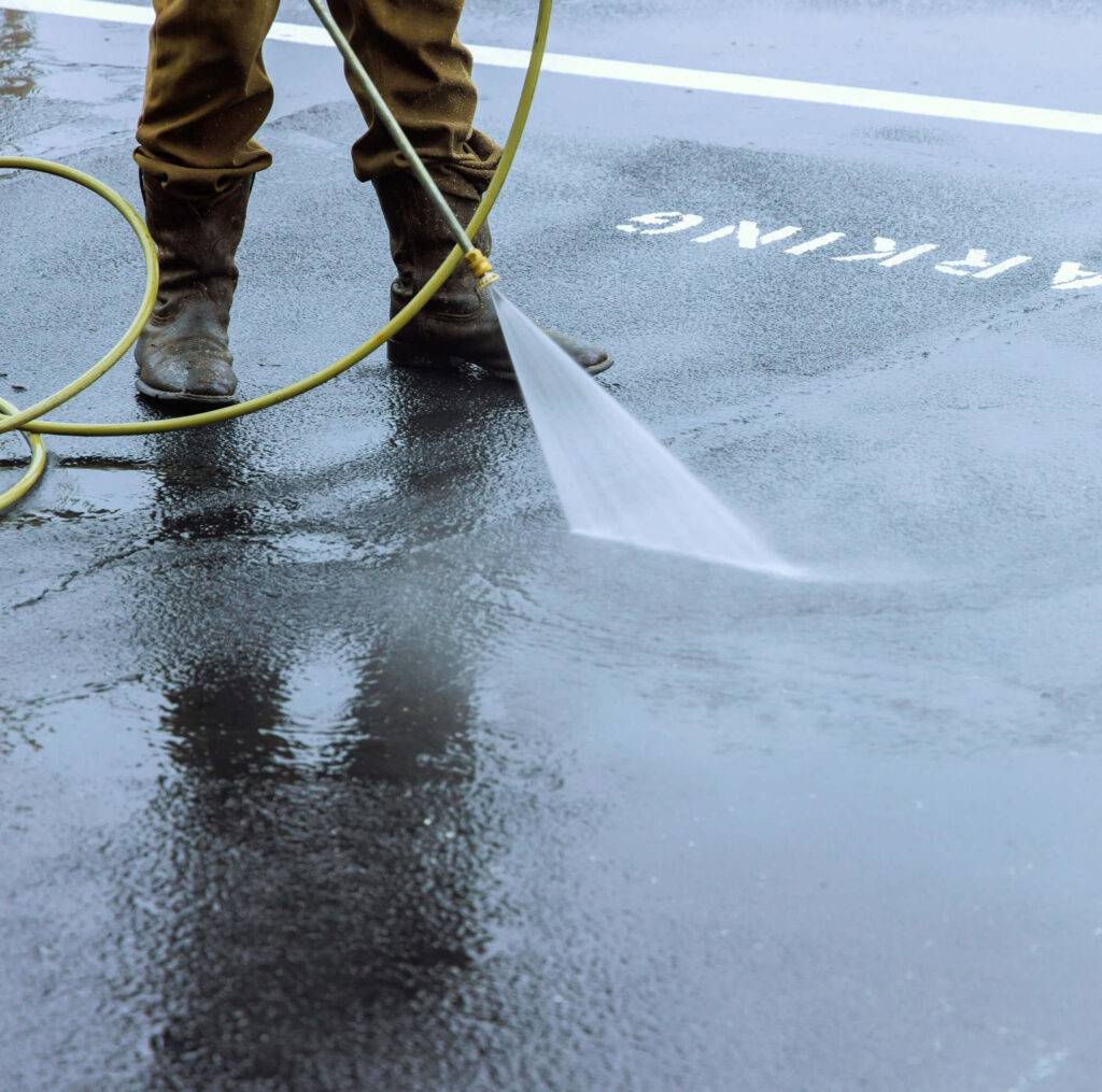 man power washing dirty sidewalk