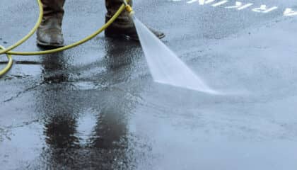 man power washing dirty sidewalk