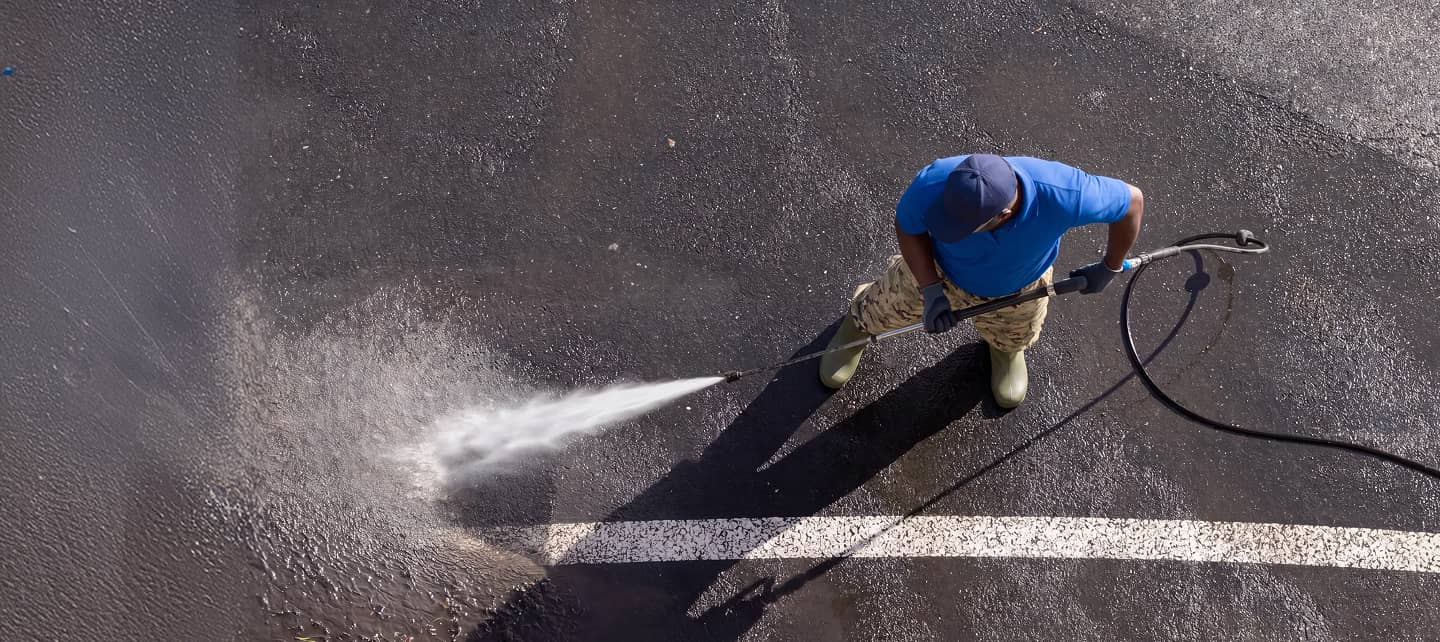 gentleman power washing parking lot
