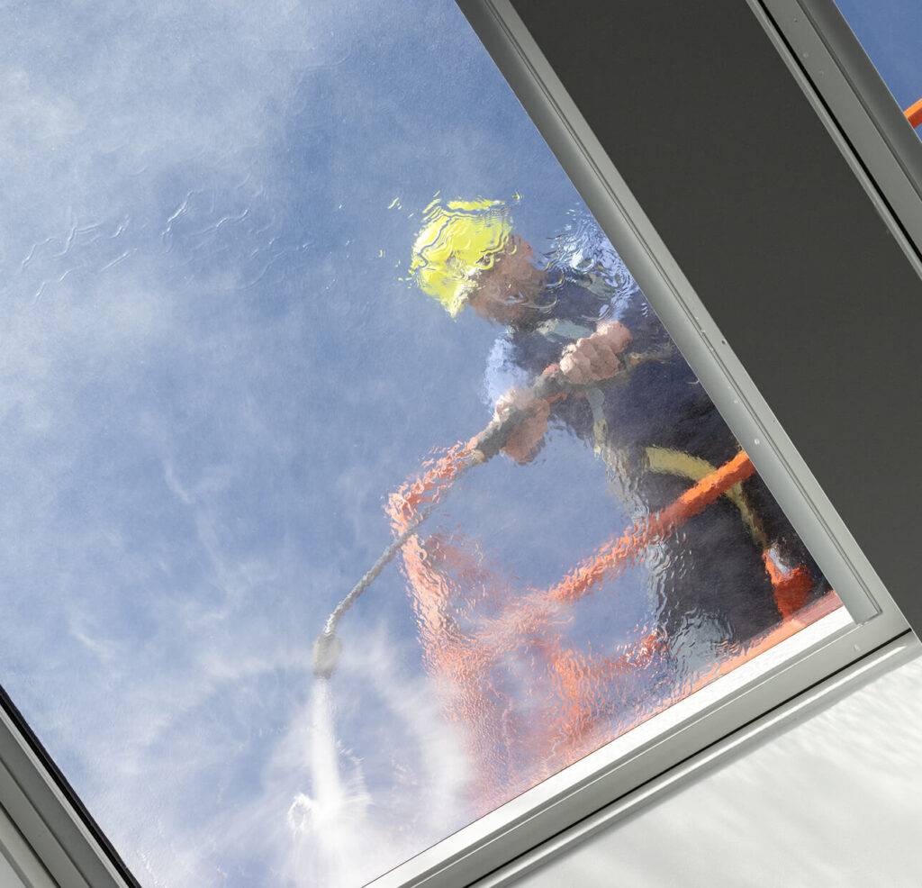 gentleman washing windows on roof